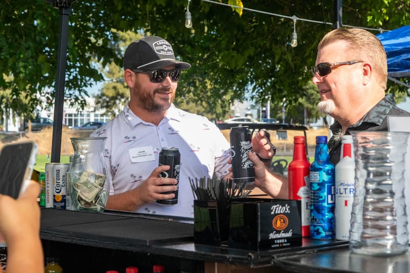 Guests enjoying drinks together at The Hangout outdoor bar at Haggin Oaks Golf Complex in Sacramento.