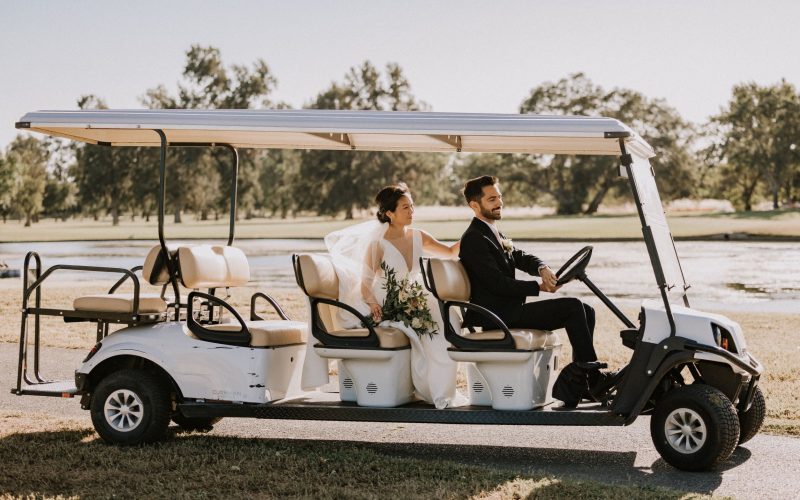 Bride and groom riding in a golf cart on the golf course after their wedding ceremony at The Pavilion at Haggin Oaks in Sacramento.